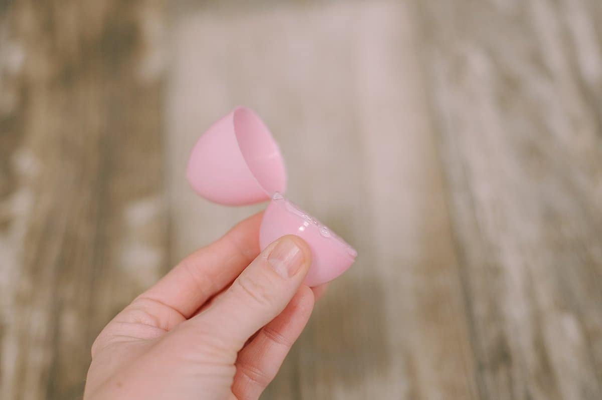 Pink plastic easter egg with hot glue along the edge between the two sections.