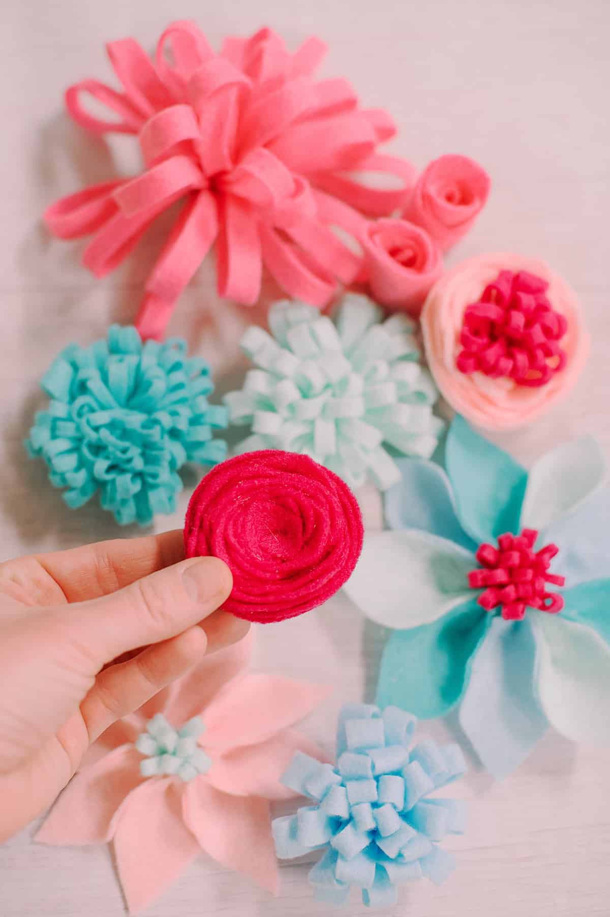 DIY felt flowers laying on a white surface.