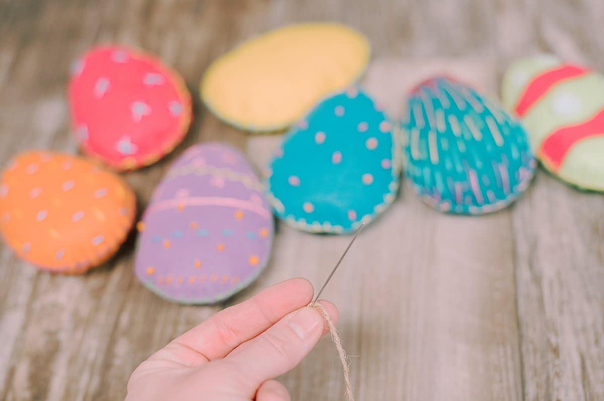 A needle and twine string with felt easter eggs.