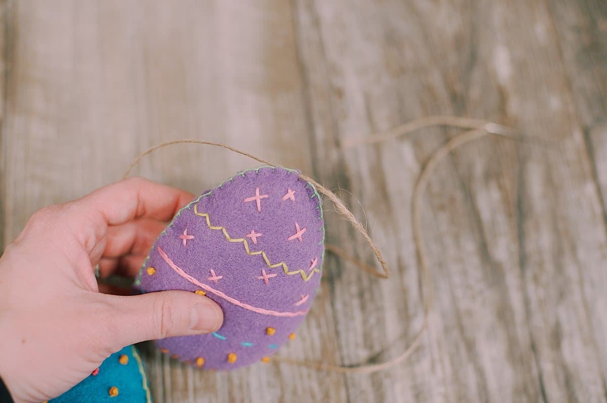 A felt egg threaded onto twine.