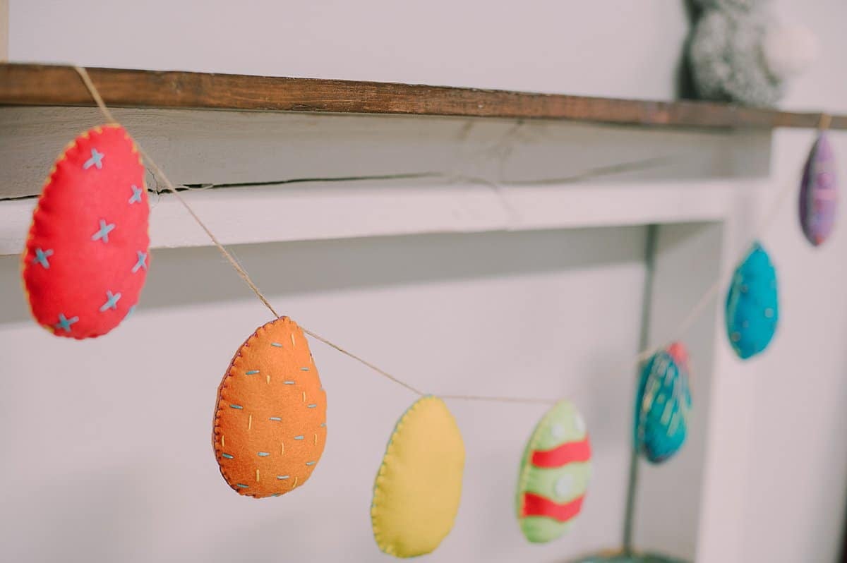 A garland made of eggs of felt with embroidered designs and edges.