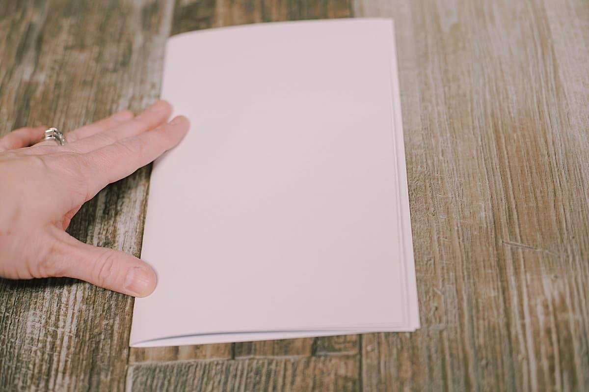 White printer paper being folded in half.