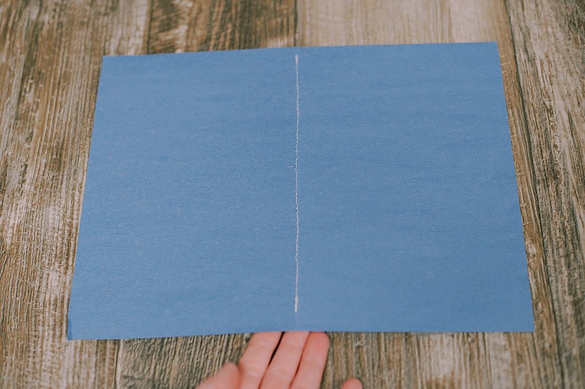 Blue paper cover with a middle seam bound by a sewing machine to make a DIY paper book.