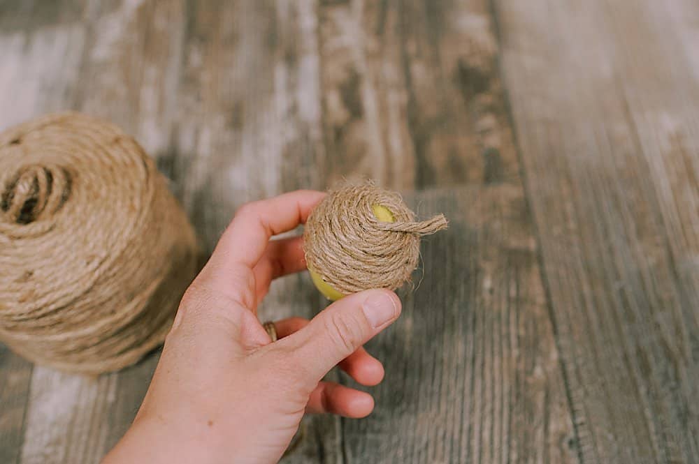 start wrapping twine around the plastic easter egg