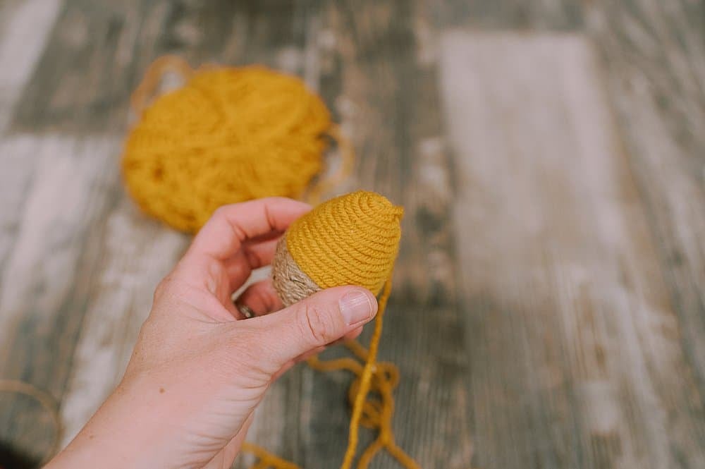 how to make DIY fall acorns using plastic easter eggs, yarn, and twine