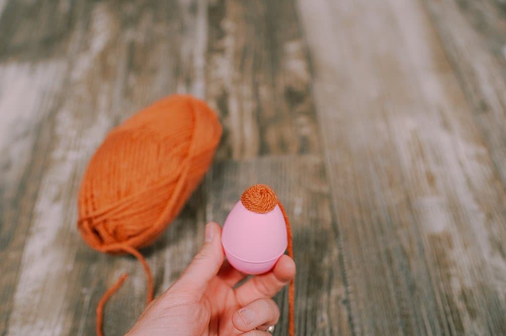 hot glue yarn to the plastic easter egg to make a fall acorn