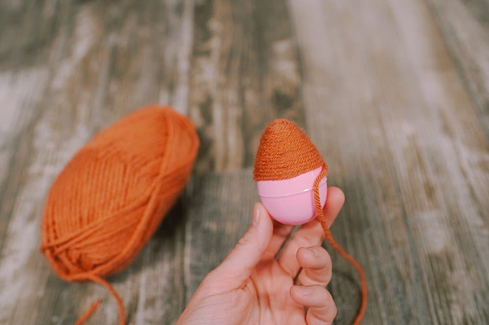 hot glue yarn to the plastic easter egg to make a fall acorn