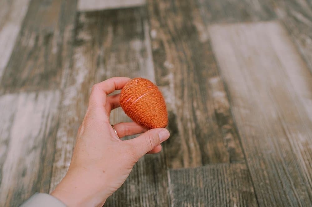 hot glue yarn to the plastic easter egg to make a fall acorn