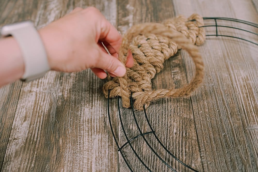 Showing the weaving of a jute rope into and out of a wire wreath form.