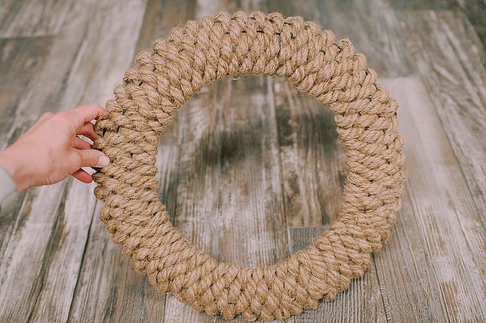 A completed wreath made out of jute rope being weaved through the wire frame.