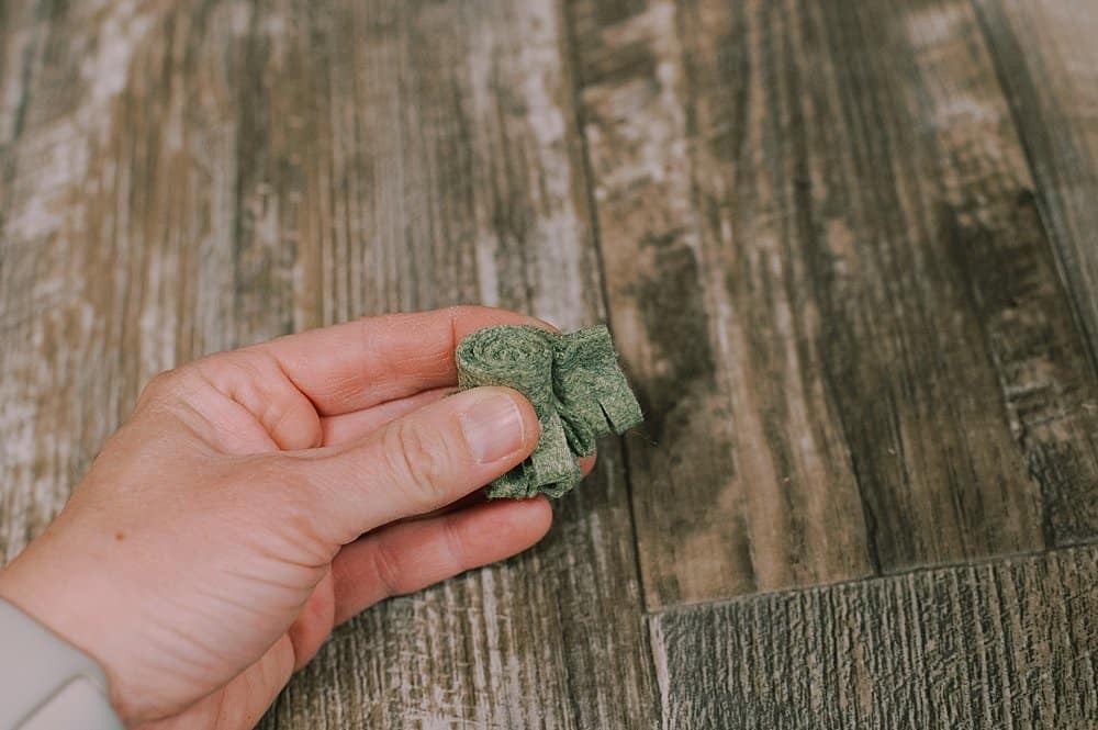 Green felt glued into a roll to make a fabric flower.