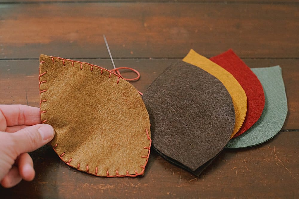 use an embroidery stitch called the blanket stitch to sew two felt leaf shapes together