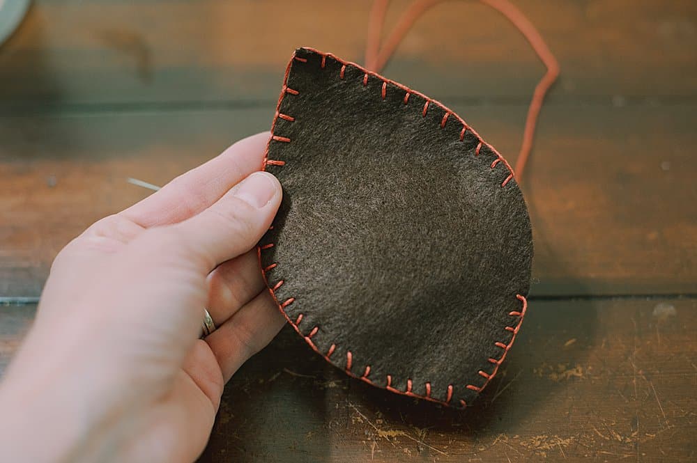 blanket stitch around the edge of two felt leaf shapes to make felt leaves