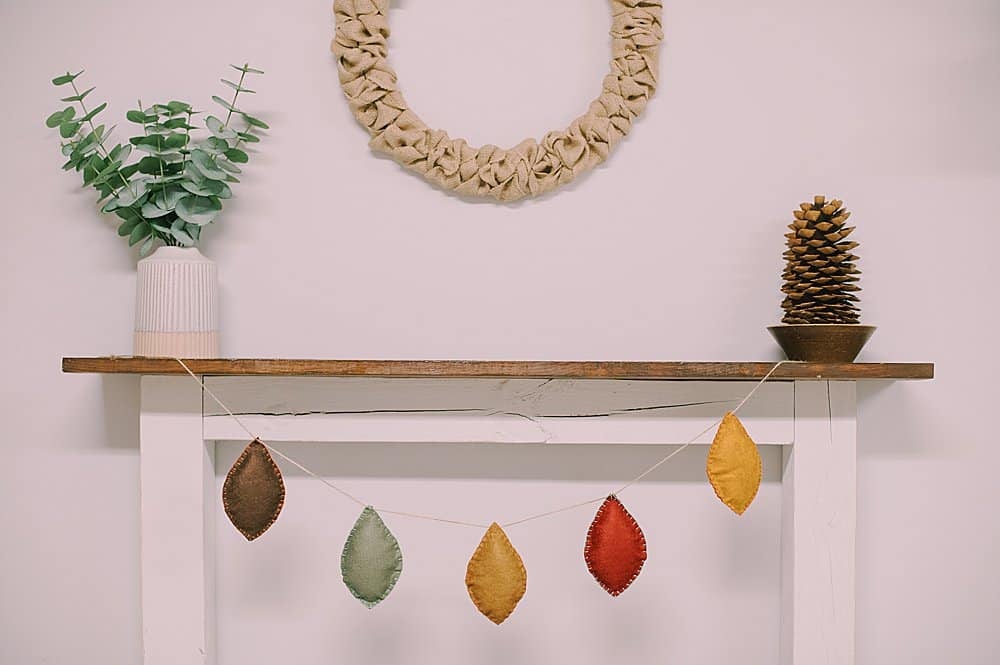 Learn how to make a felt leaf garland using felt leaves, stuffed with fiber fill and embroidered with a blanket stitch, and strung with twine!