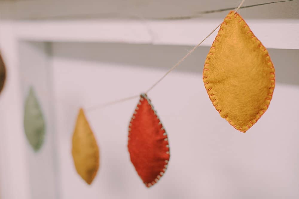 Learn how to make a felt leaf garland using felt leaves, stuffed with fiber fill and embroidered with a blanket stitch, and strung with twine!