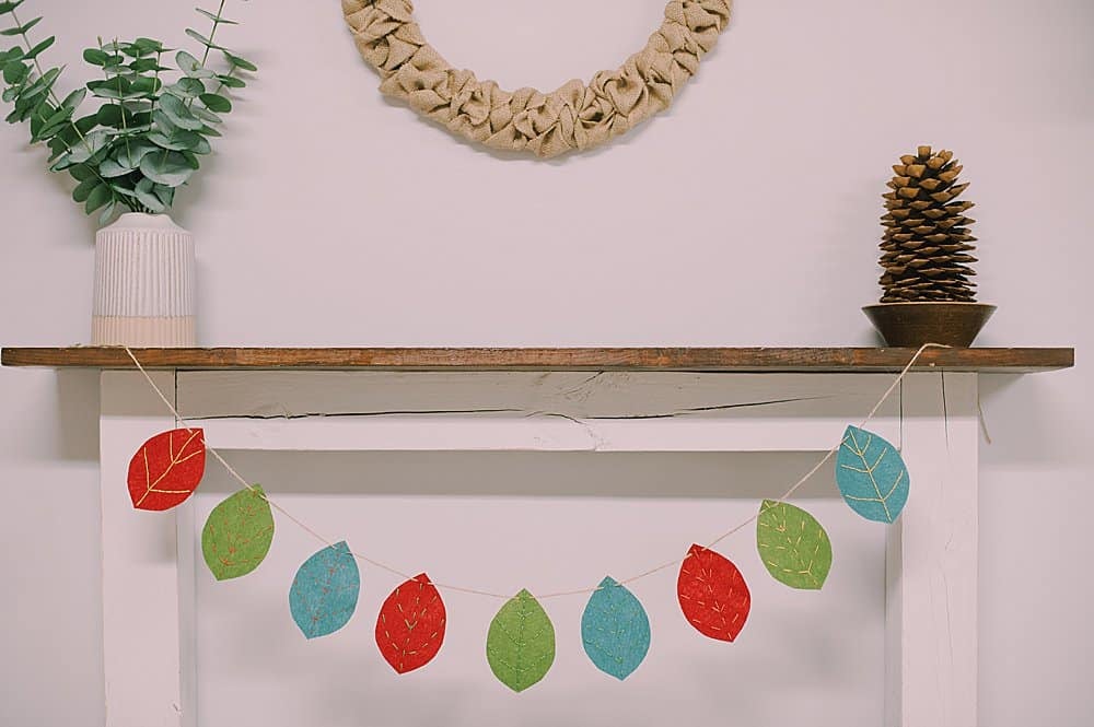 Learn how to make an embroidered felt leaf garland using felt leaves with embroidery floss veins, strung into a garland using twine!