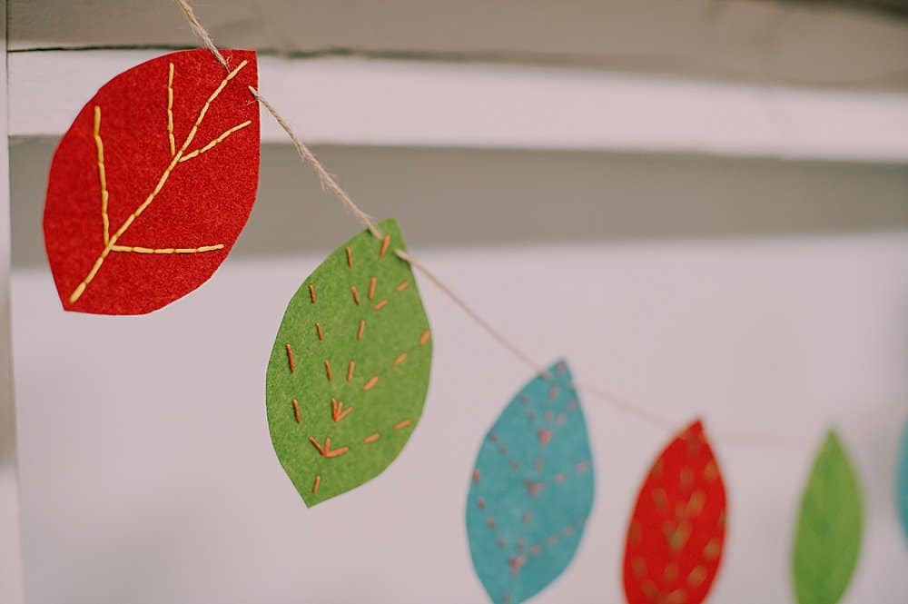 Learn how to make an embroidered felt leaf garland using felt leaves with embroidery floss veins, strung into a garland using twine!