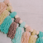 How to Make a Pastel-Colored Yarn Tassel Garland using yarn that is pastel colors for spring or summer.