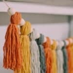 How to make a Fall Tassel Garland using yarn and wooden beads and twine as the hanging string.