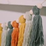 How to make a Fall Tassel Garland using yarn and wooden beads and twine as the hanging string.