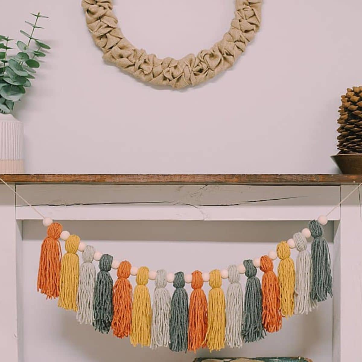 How to make a Fall Tassel Garland using yarn and wooden beads and twine as the hanging string.