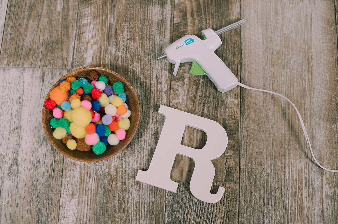 Supplies to make a pompom letter R.