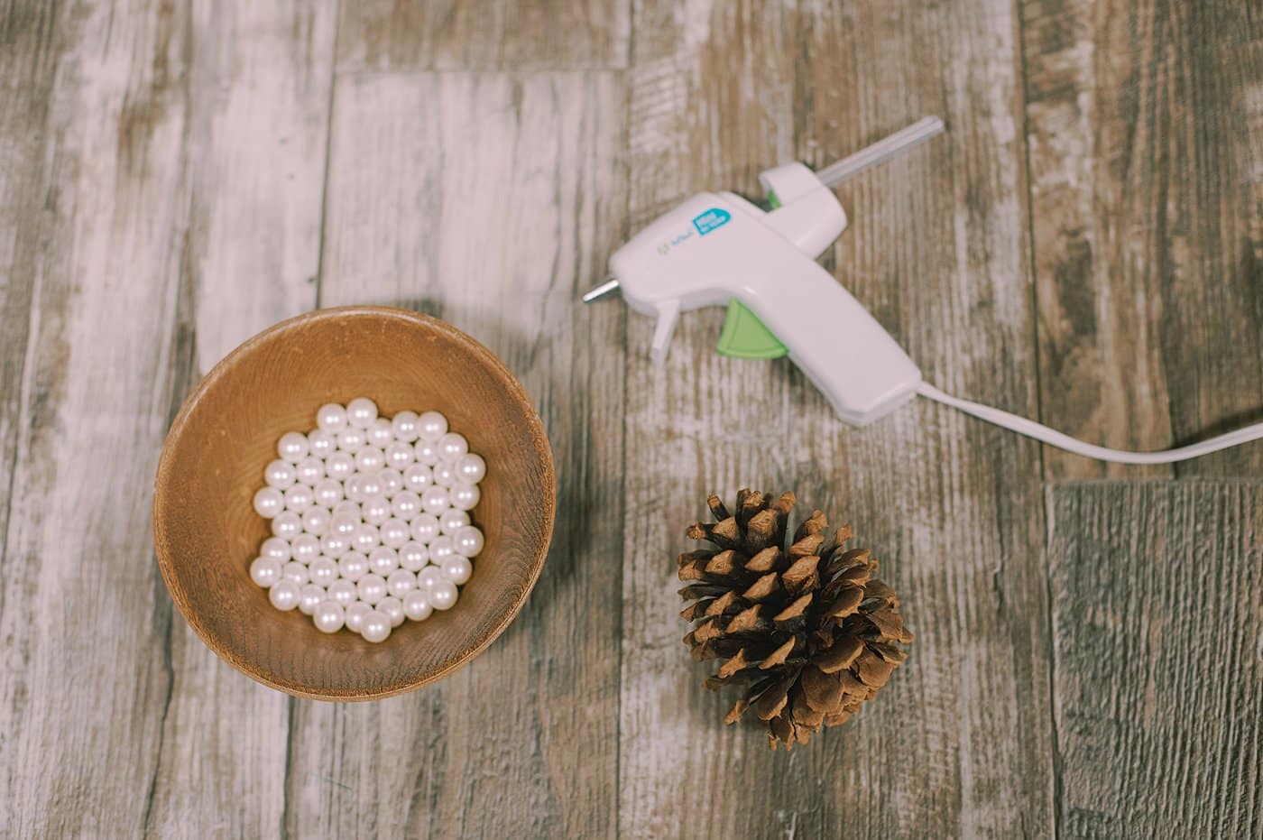 Gather supplies to make a pine cone with pearls on the ends.