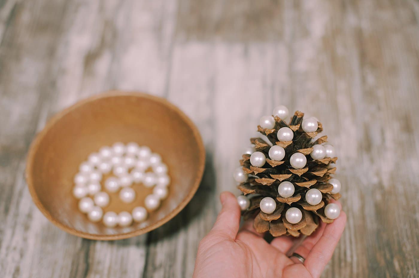 Hot glue pearls to the ends of the pine cone.