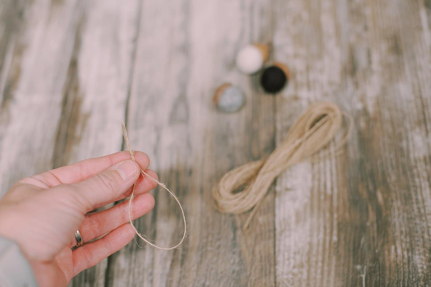 Hot glue twine to the acorn cap of the felt ball acorn.