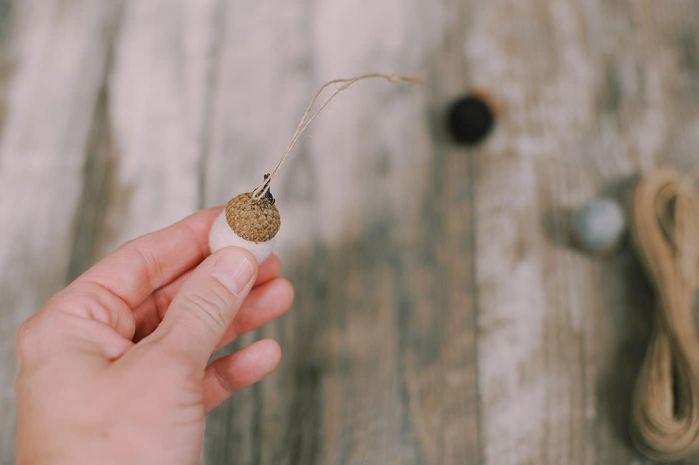 Hot glue twine to the acorn cap of the felt ball acorn.