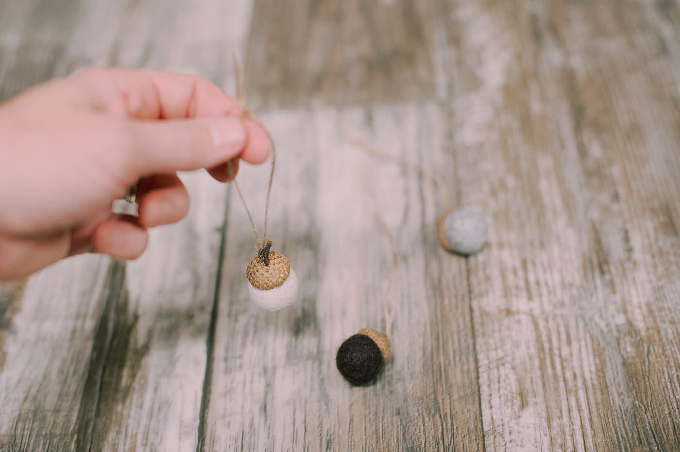 Hot glue twine to the acorn cap of the felt ball acorn.