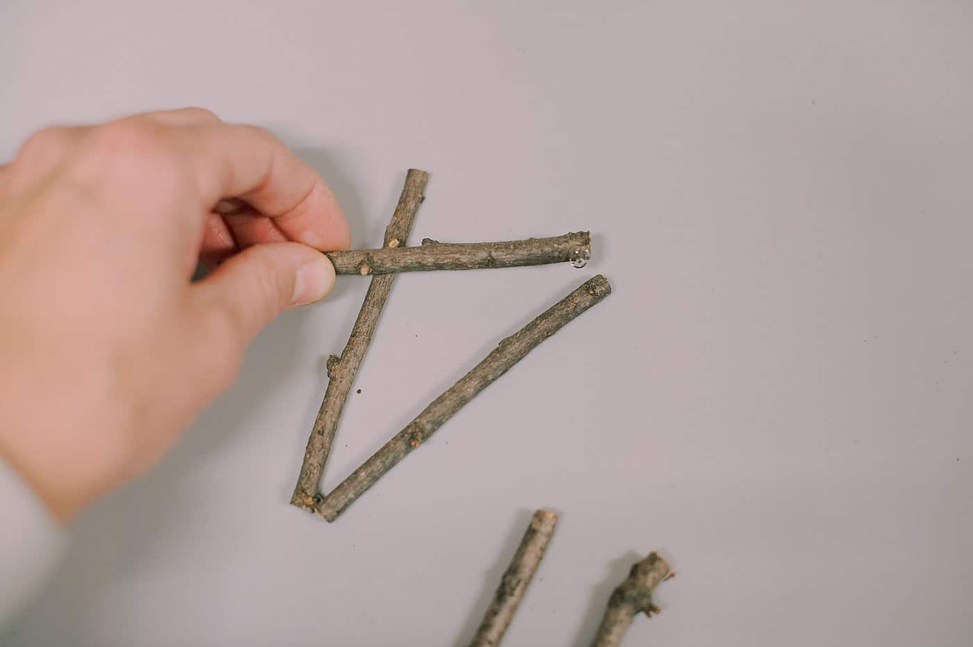 Hot glue sticks into shapes to make christmas ornaments.