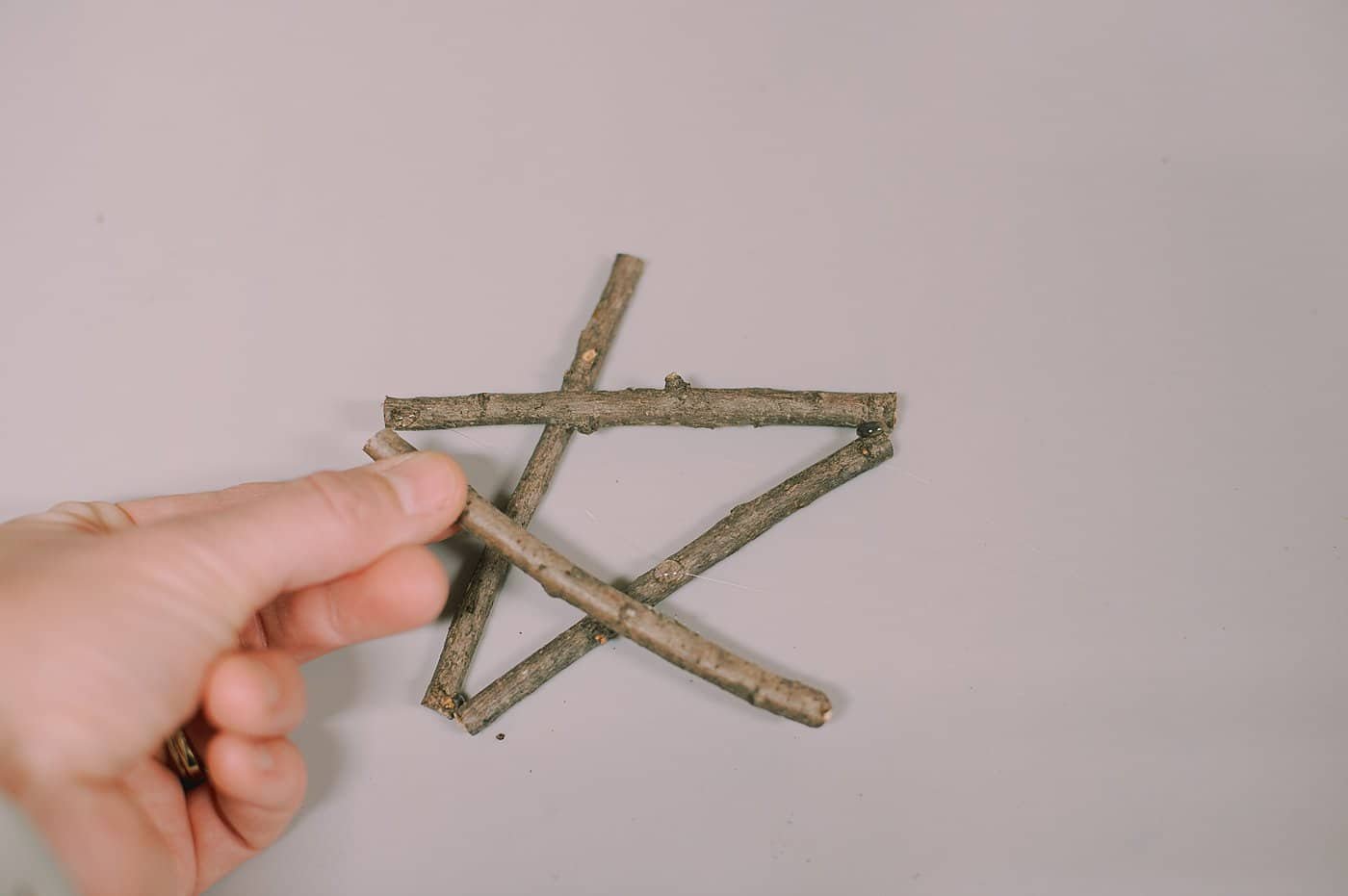 Hot glue sticks into shapes to make christmas ornaments.