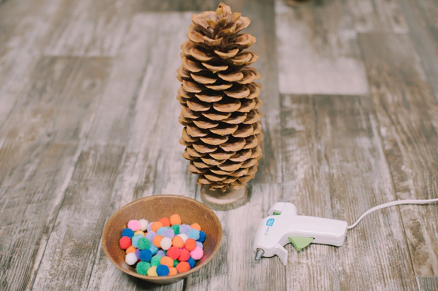 Supplies needed to make a giant pinecone Christmas tree with pompoms.