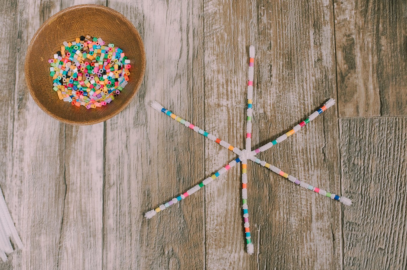 Keep adding beads to the pipe cleaners until the snowflake is filled.