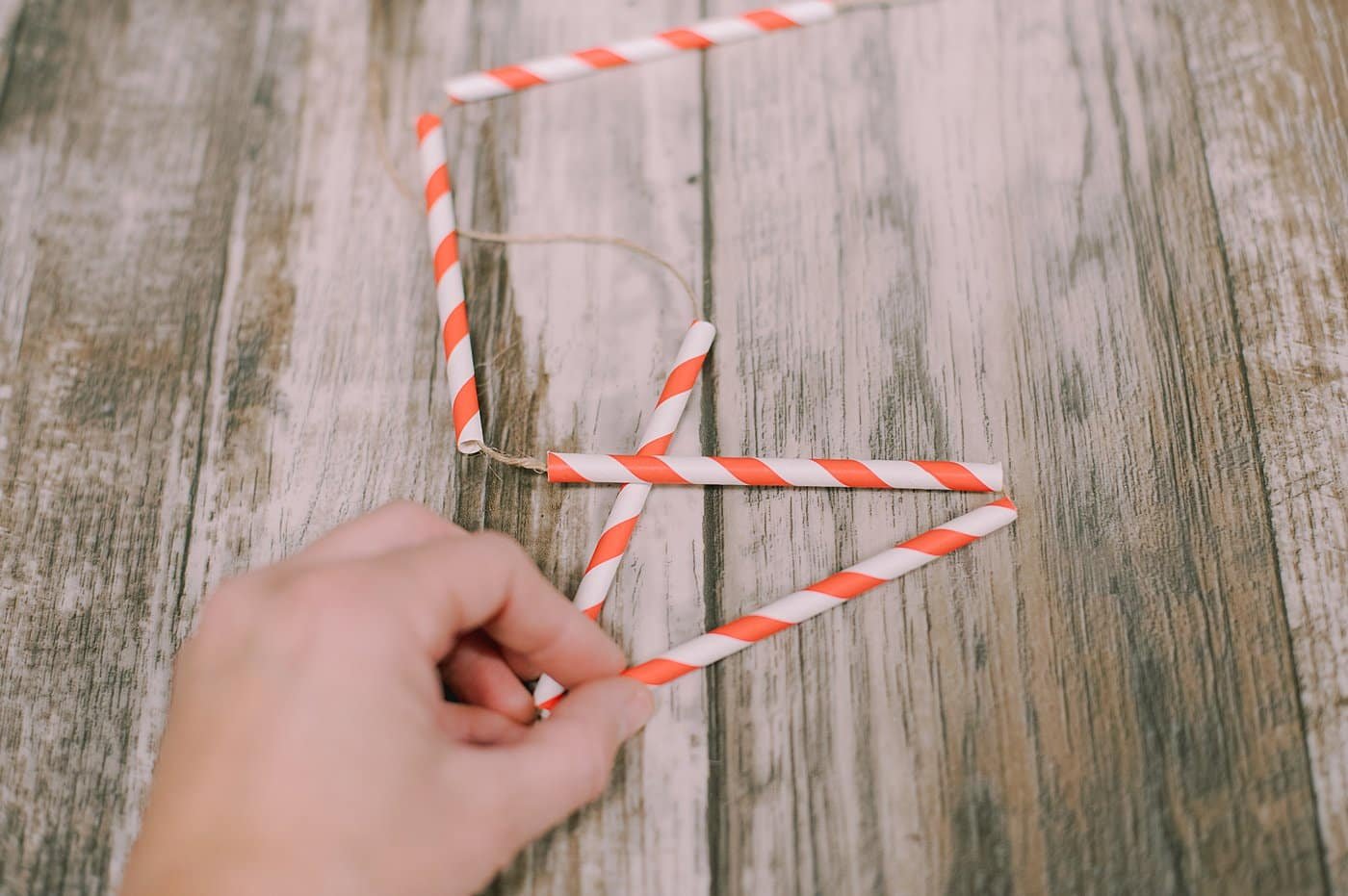 String straws onto twine.