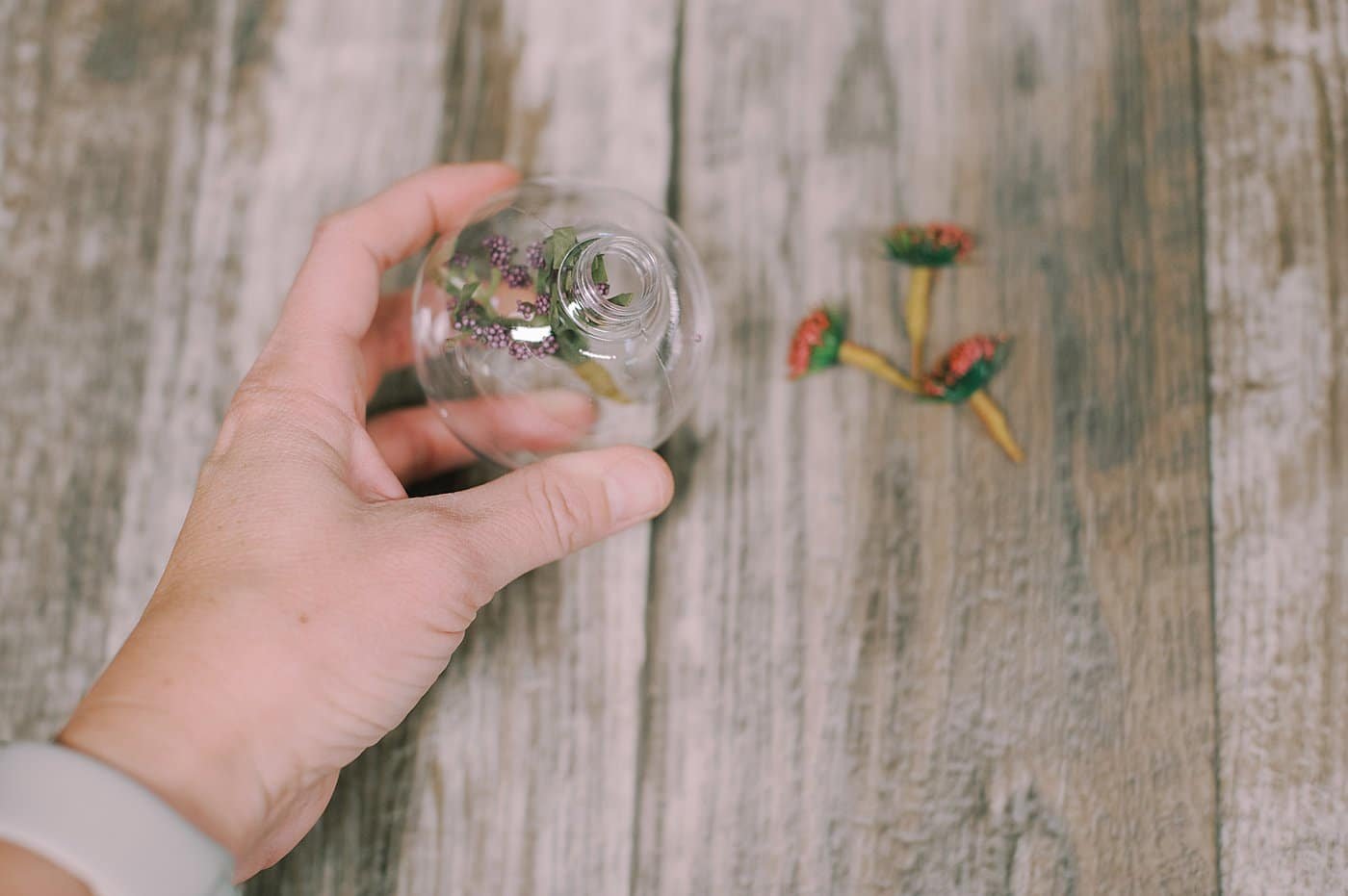 Put fake flowers into the glass or plastic christmas ball ornament.