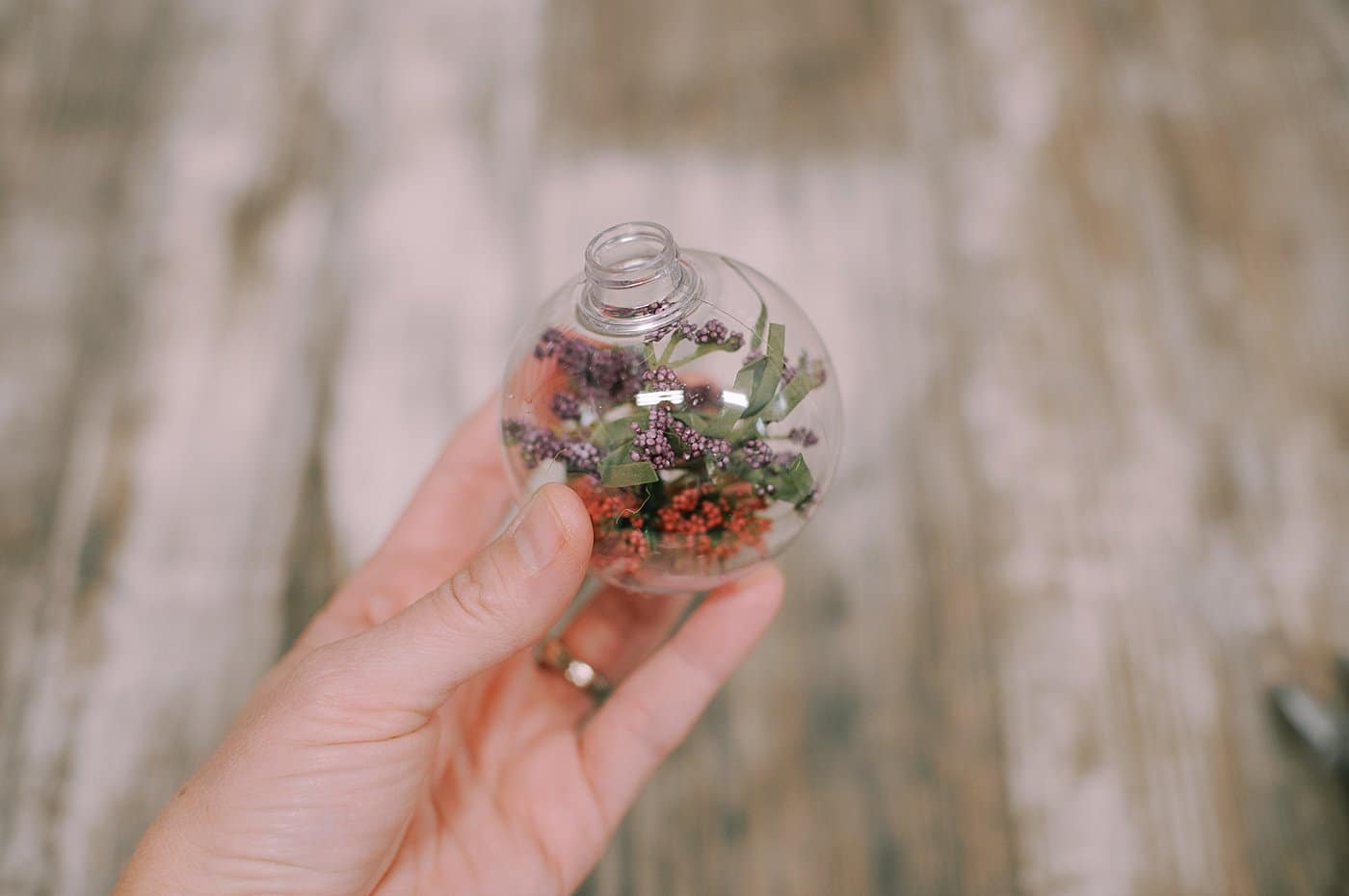 Put fake flowers into the glass or plastic christmas ball ornament.