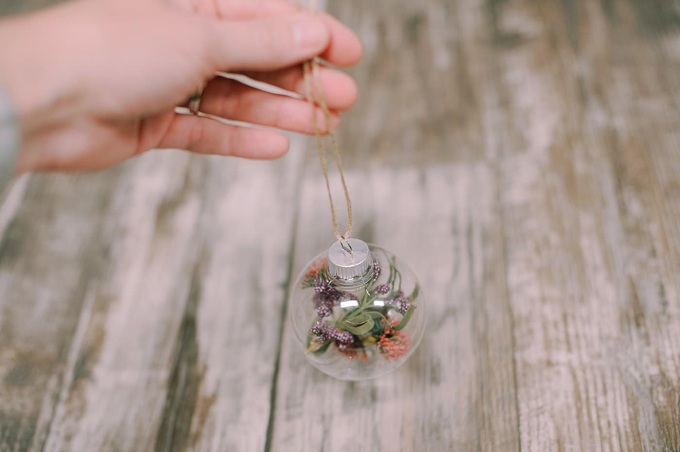 Hot glue the top of the glass ball ornament on and thread twine through to hang.