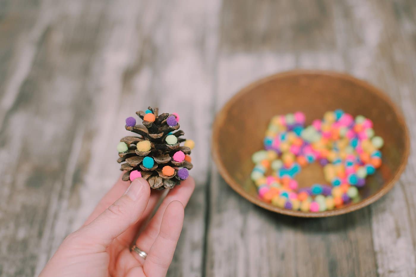 Add pom poms to the pine cone tree.