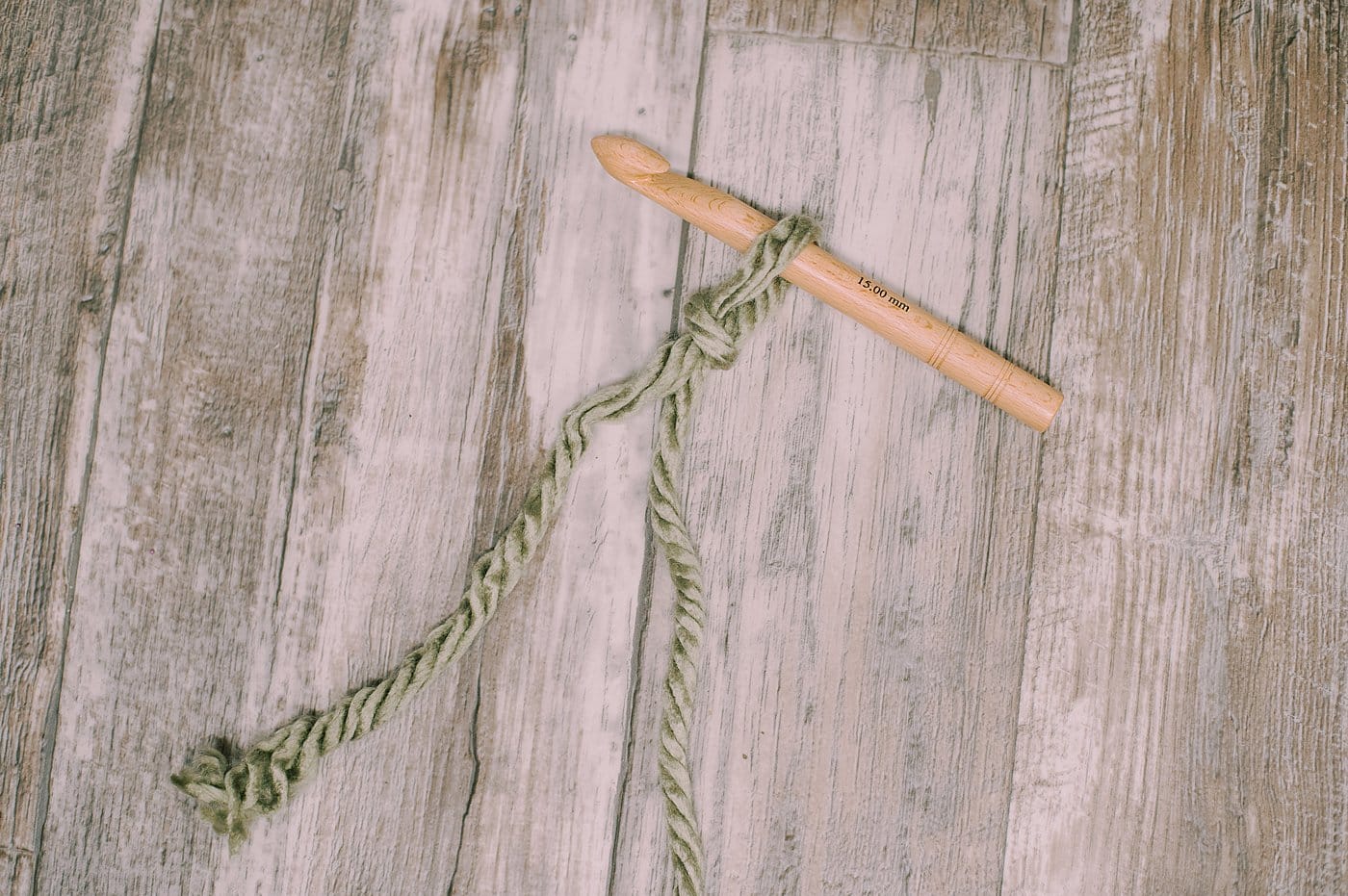 A crochet hook with a yarn slip knot on it.