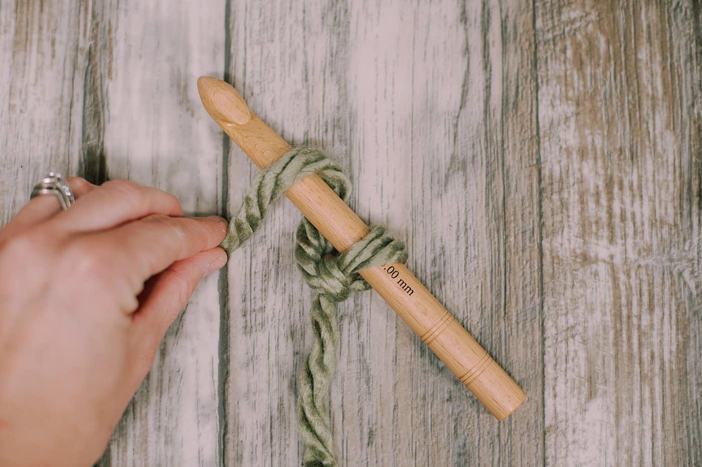 Wrapping yarn around a crochet hook to do a chain stitch.