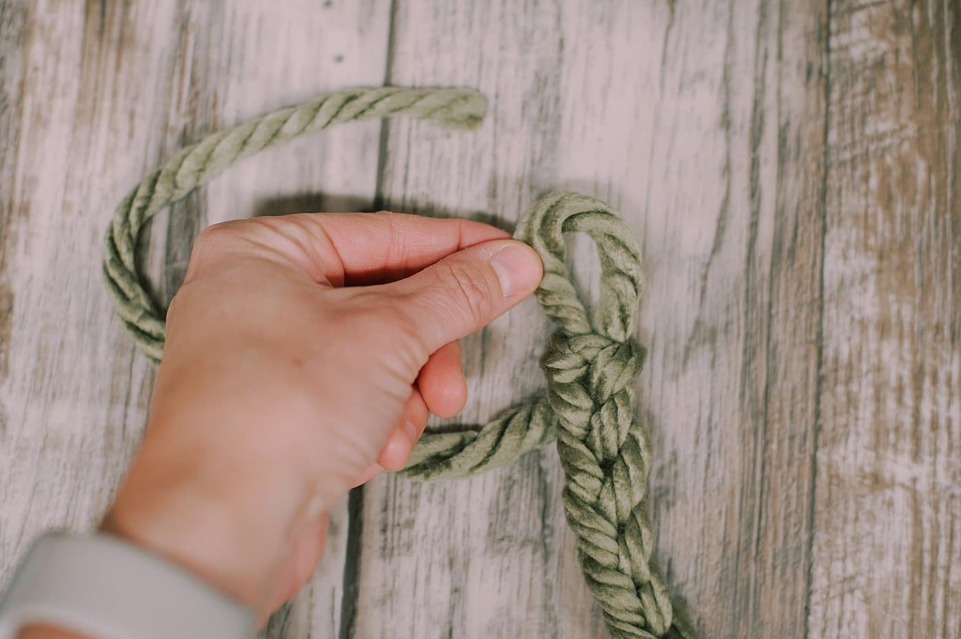 A loop at the end of the chain stitched yarn garland.
