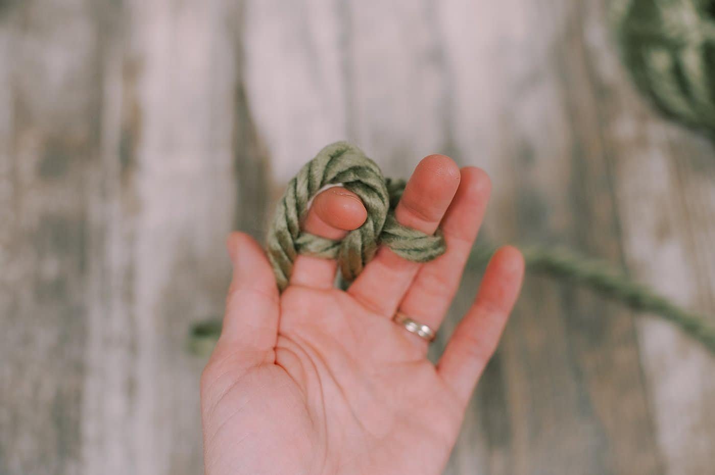 Showing how to finger knit using yarn.