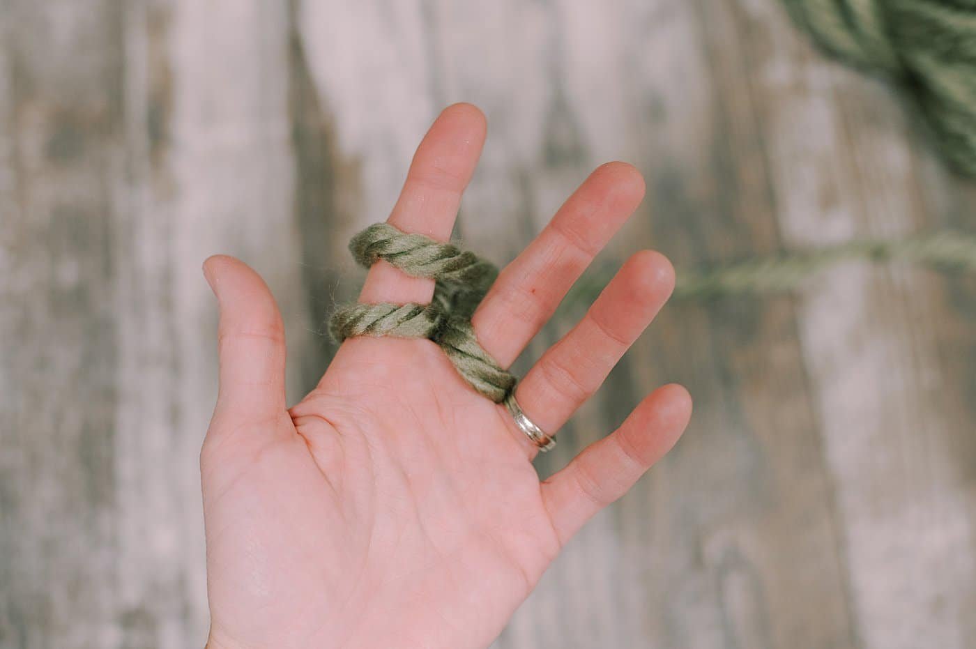 Showing the steps of finger knitting with chunky yarn.