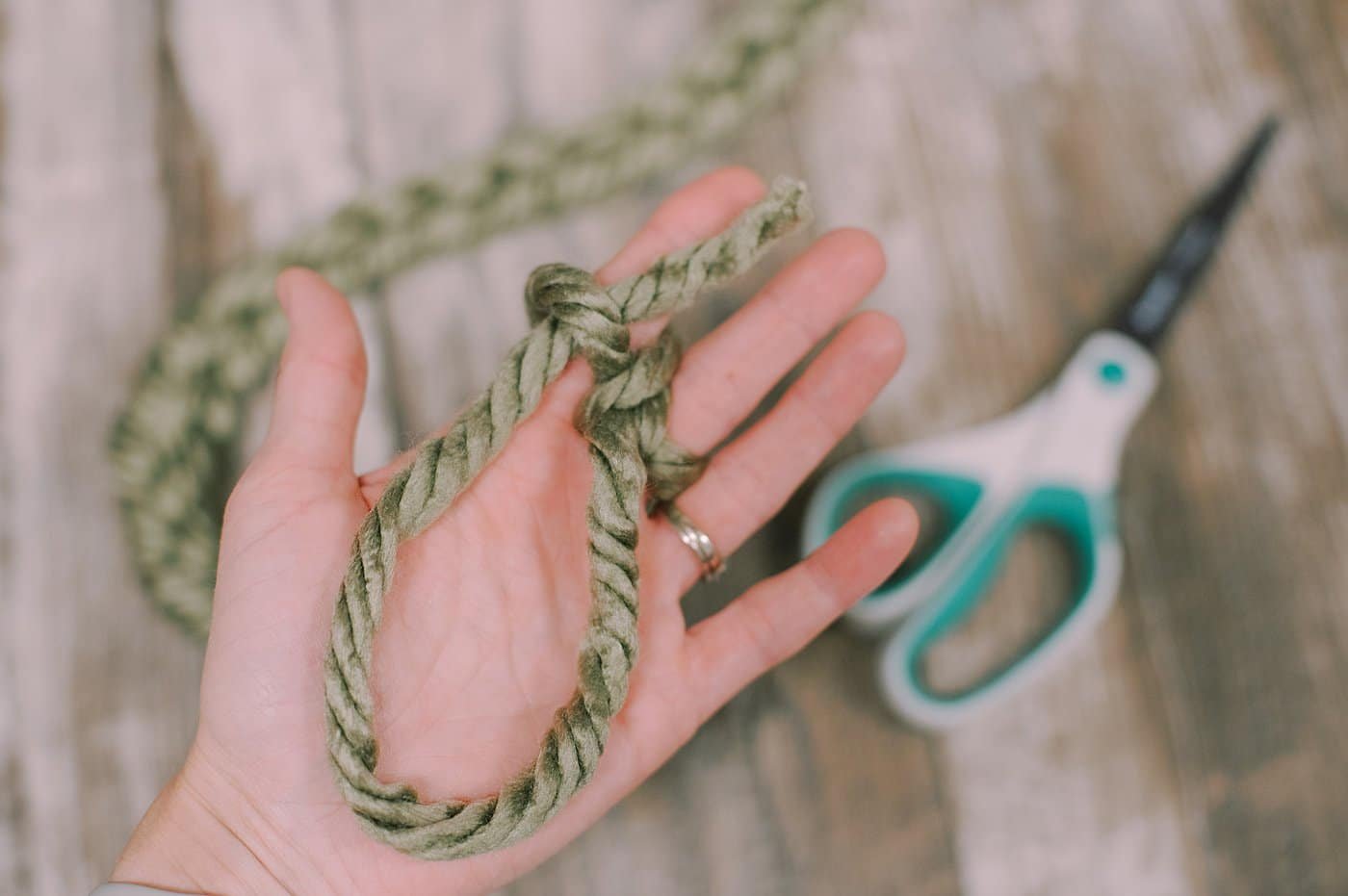 Finishing off a chunky yarn finger-knit garland.