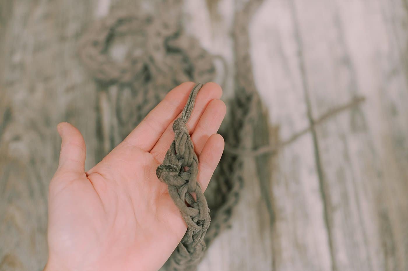 The end of a finger-knit garland made using homemade t-shirt yarn.