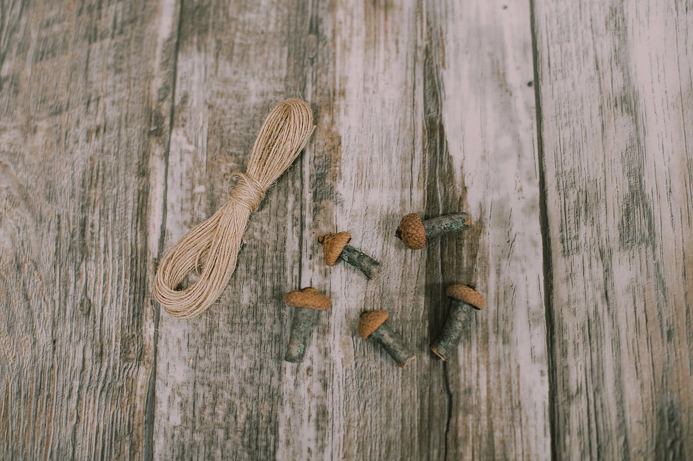 Hot glue twine to the acorn cap as a hanging string for the tiny mushroom ornaments.