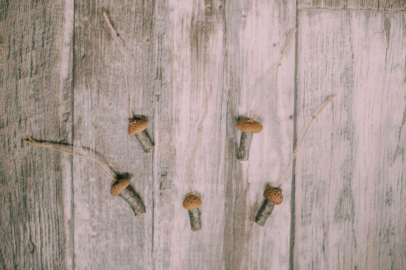 Hot glue twine to the acorn cap as a hanging string for the tiny mushroom ornaments.