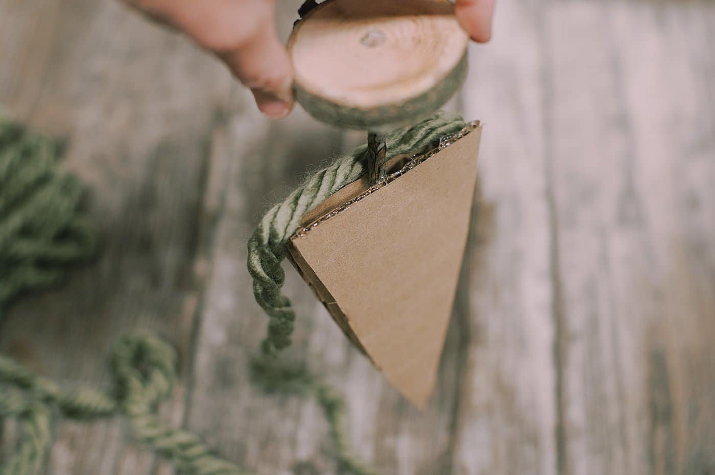 hot glue yarn to the bottom of the cardboard pieces to make a yarn wrapped cardboard tree